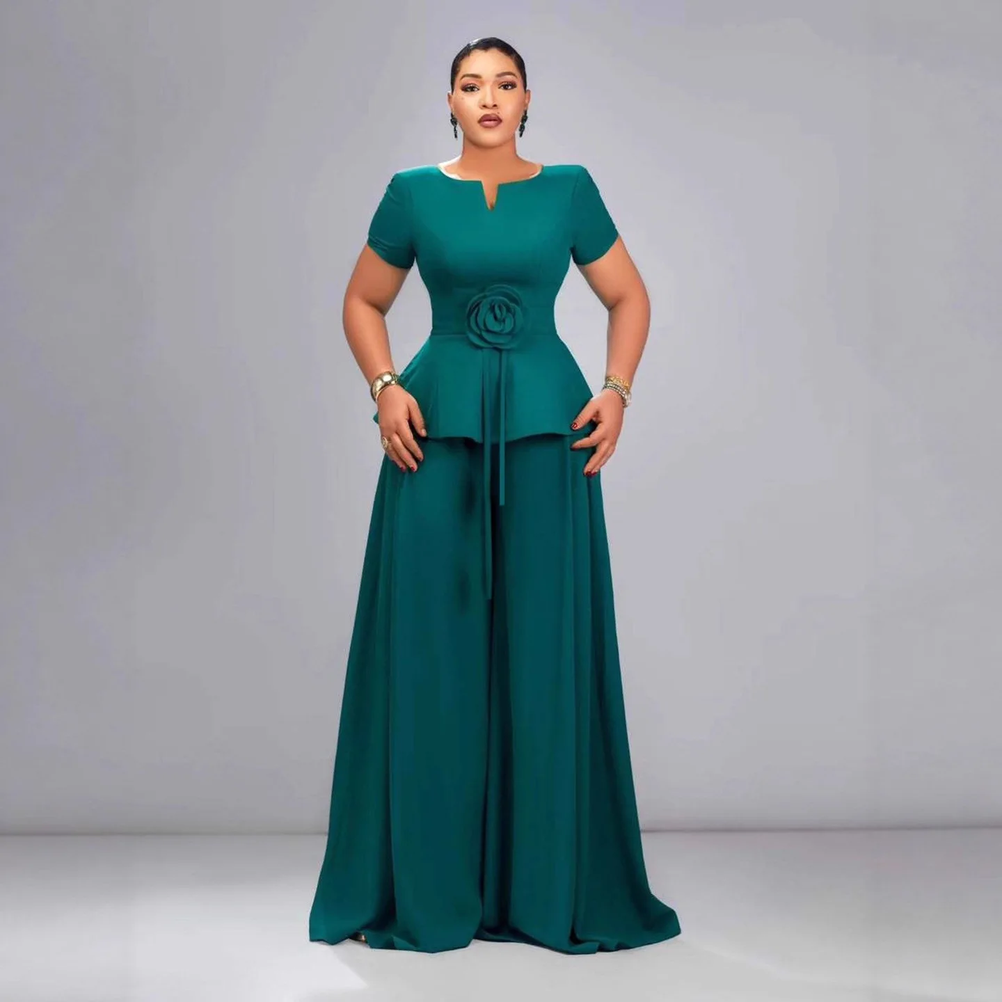 

Комплект женской одежды больших размеров: темно-зеленый топ с коротким рукавом, оборками и объемными цветами, и длинные брюки с широкими штанинами в стиле Y2K