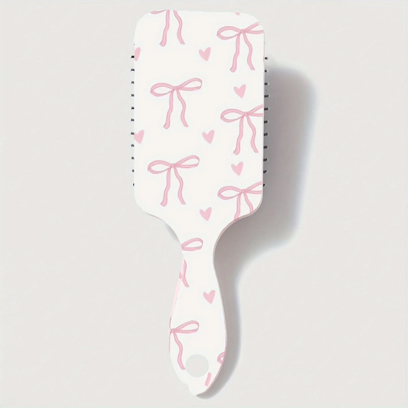 

Cute cartoon-style cushion comb with bow and heart pattern, designed for girls, portable and easy to use at home.