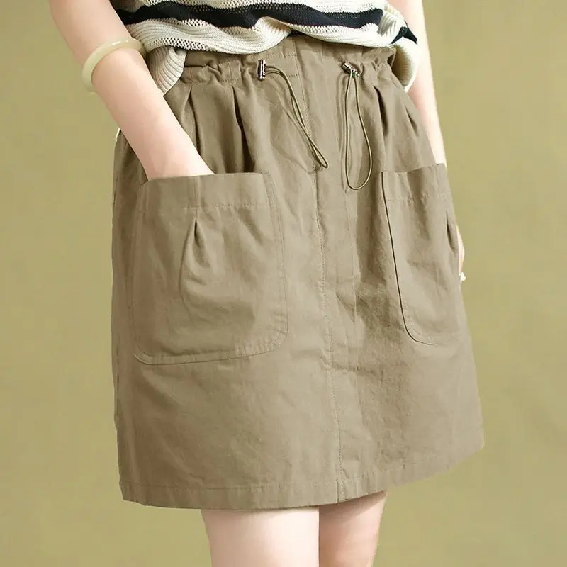 Moda elástica shirring emendado bolsos saias casuais roupas femininas 2025 verão novo solto all-match saias de cintura alta