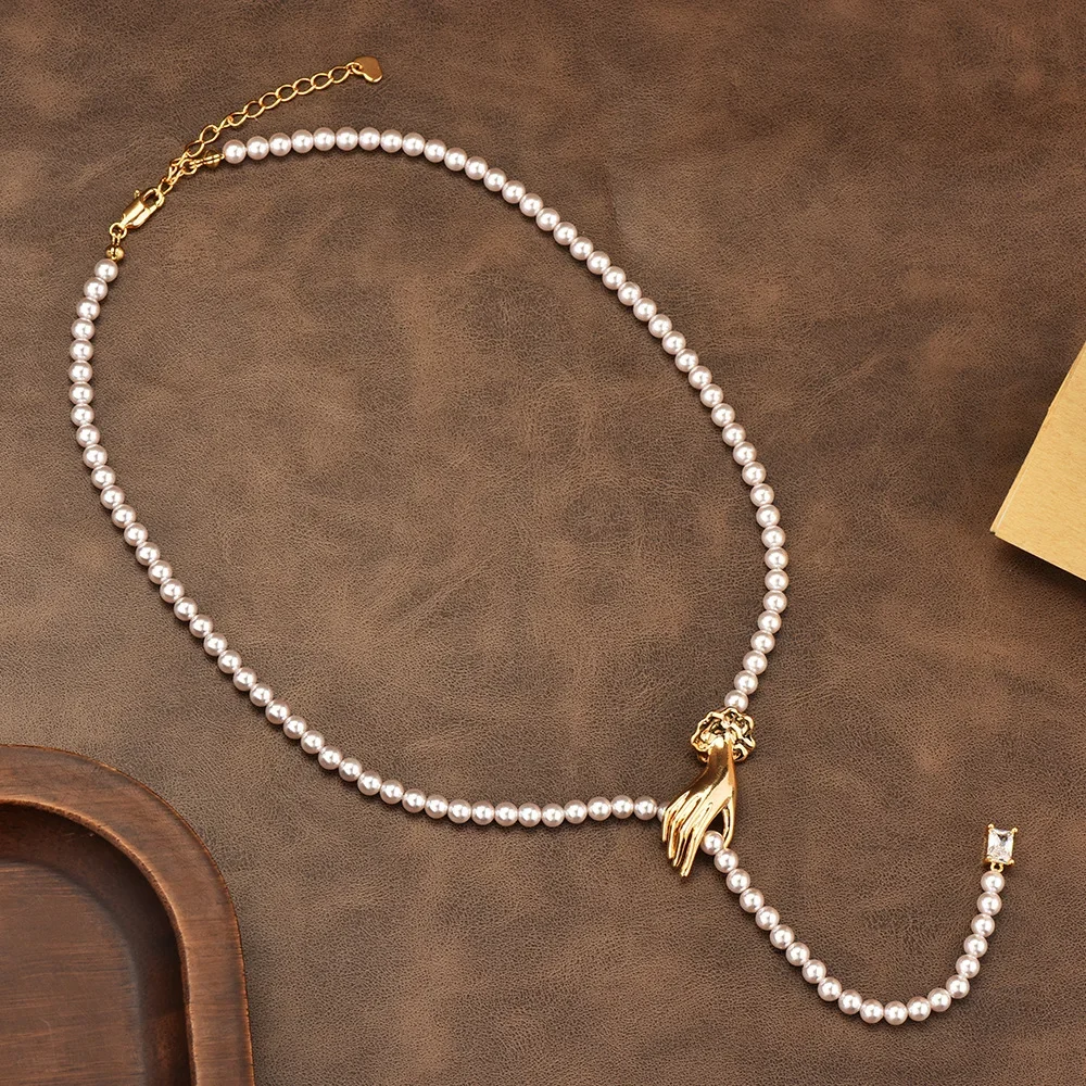 

A woman holding a pearl necklace, a light luxury collarbone chain, a simple sweater chain and a neck chain