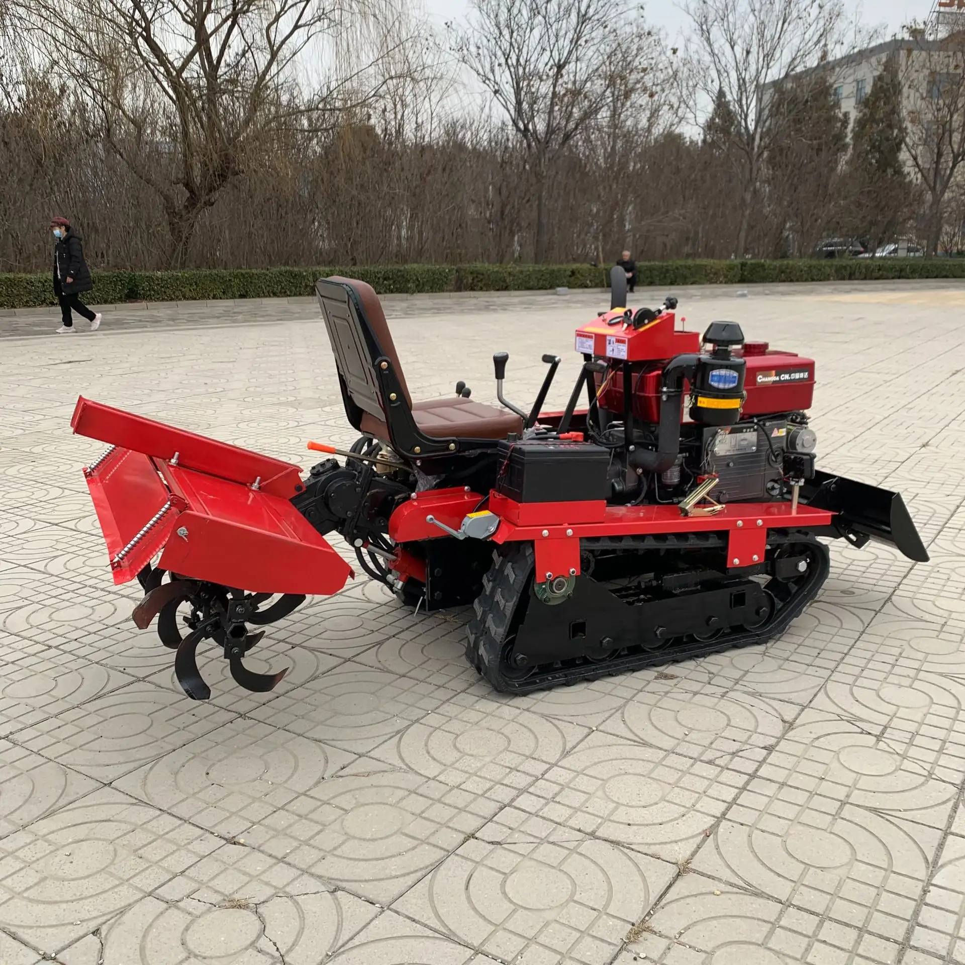 Household small agricultural rotary tiller rides on tracks with engine core for hard and clay trenching