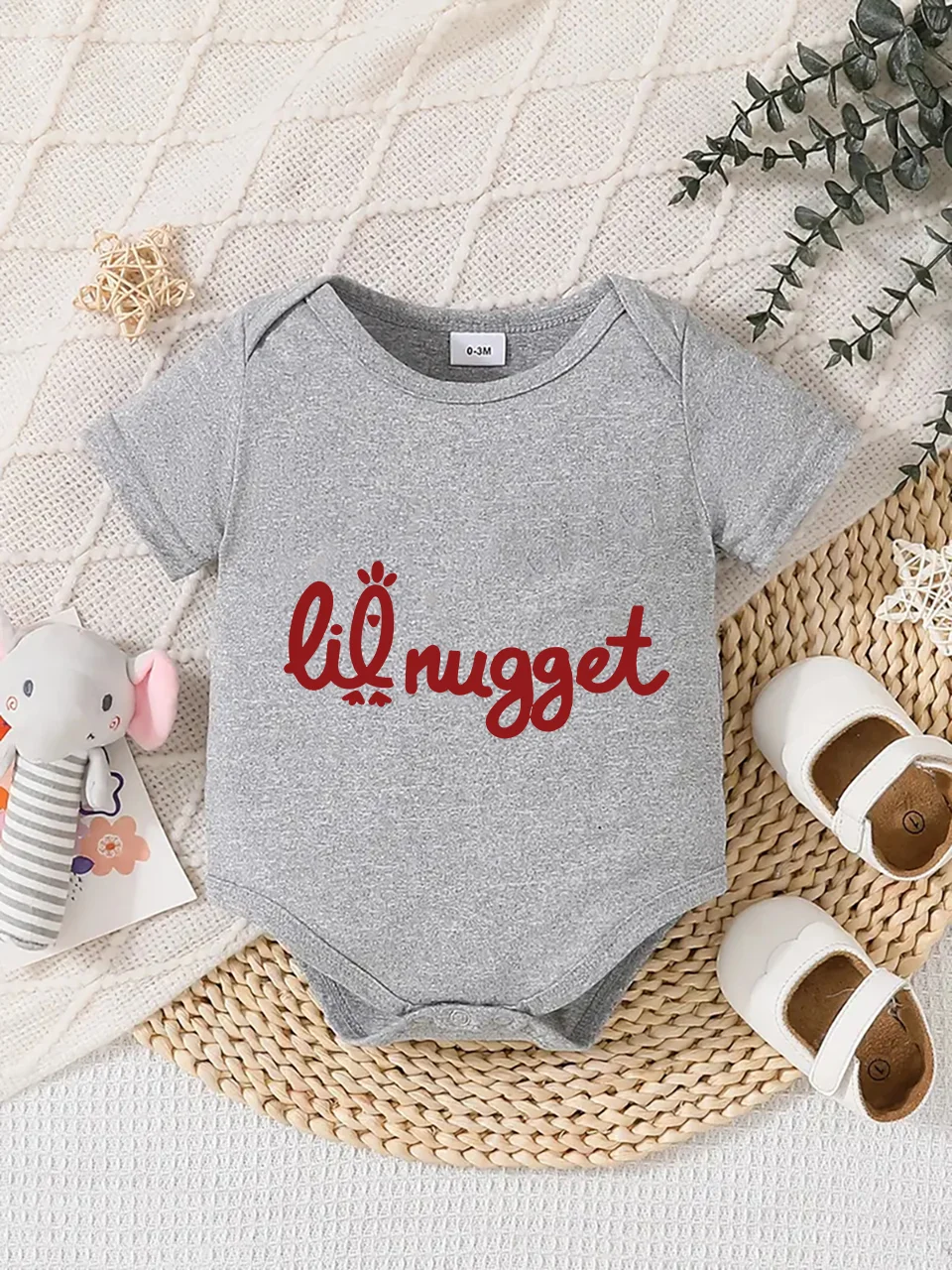 Playful letter-printed baby short-sleeve triangle bodysuit. Button closure for easy dressing