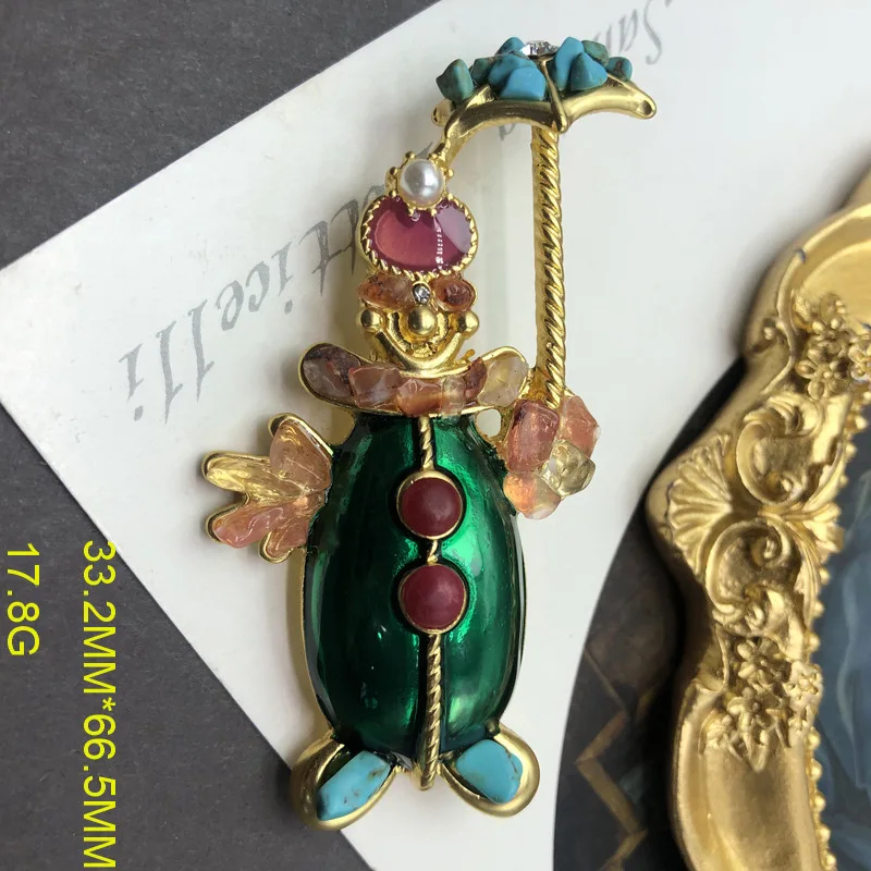 

Medieval style three-dimensional green enamel glaze clown colored stone element brooch