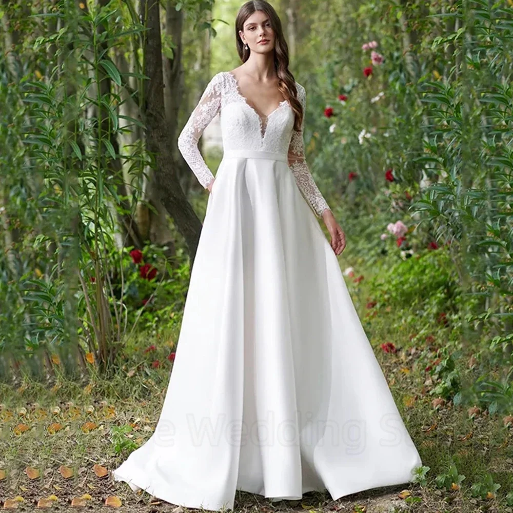 فستان زفاف أنيق بأكمام طويلة من الدانتيل والساتان ورقبة على شكل حرف V بطول الأرض مع أزرار وجيب فساتين زفاف بحزام خلفي مفتوح