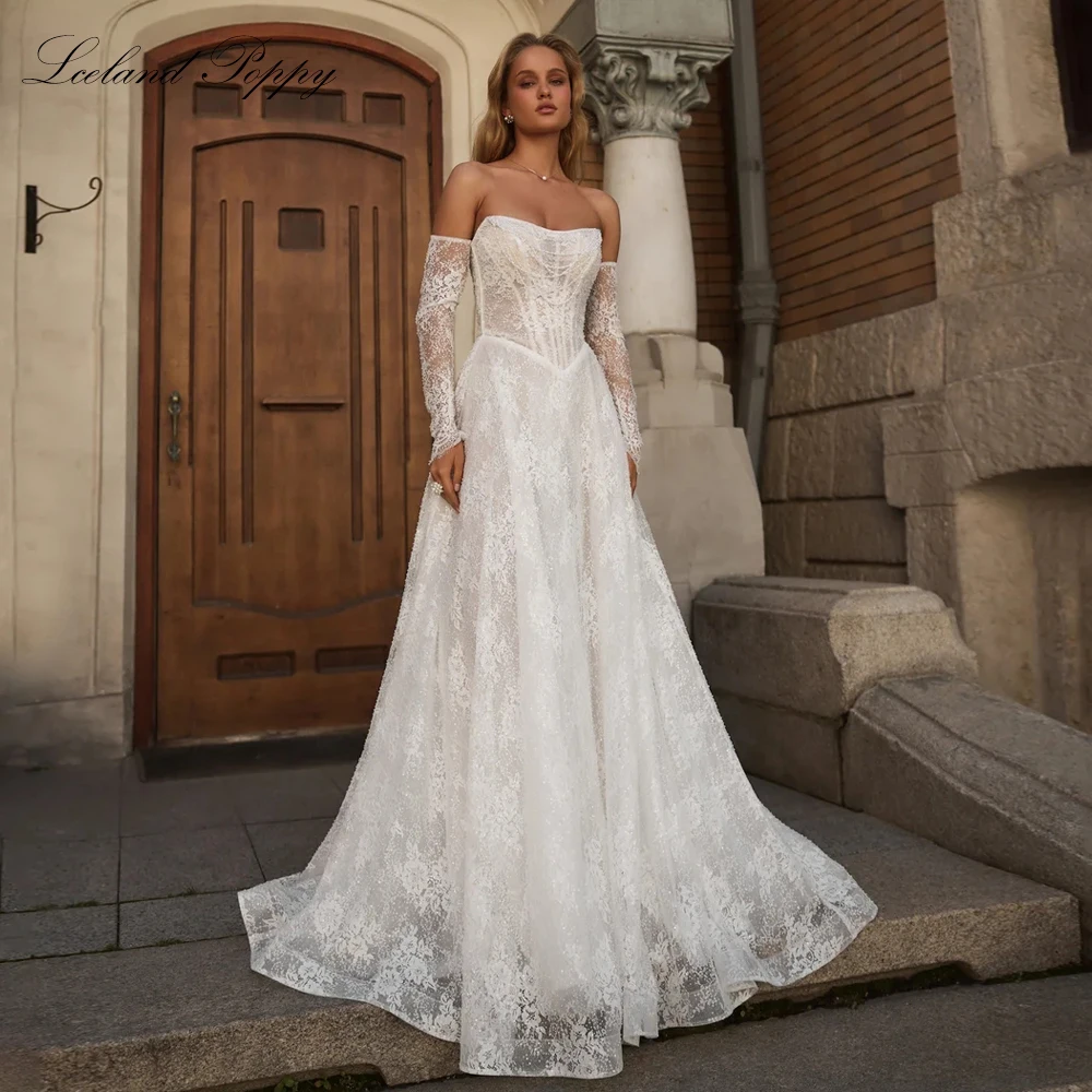 

Свадебные платья Lceland Poppy на заказ, фасона А-линия, без бретелек, с прозрачными вставками, расшитые бисером и кружевом, со шлейфом.