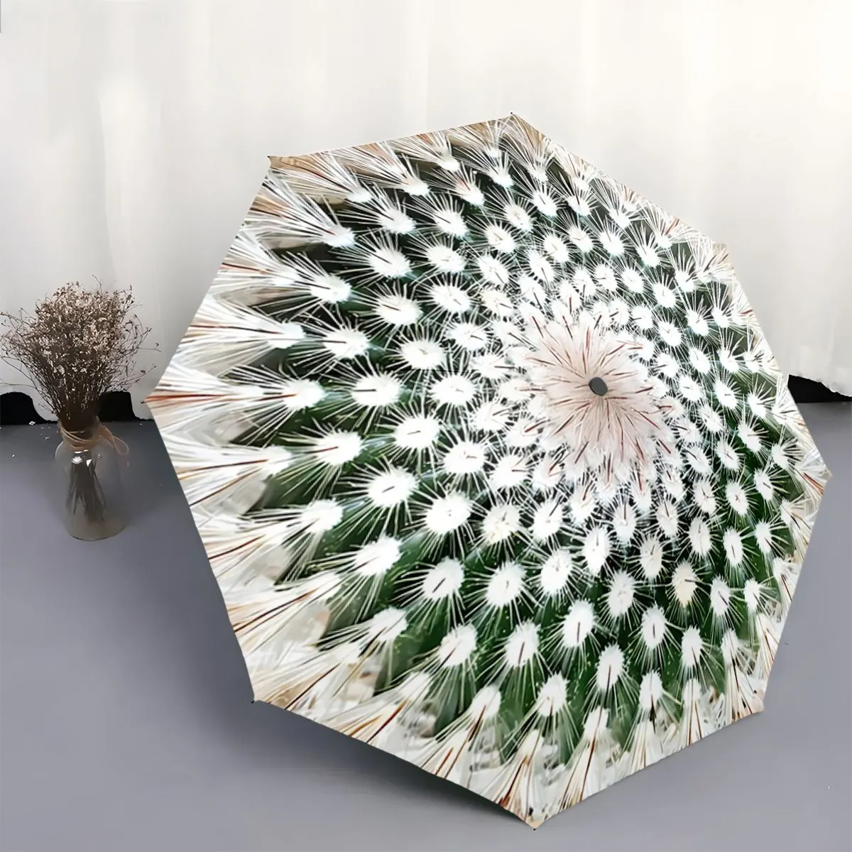 

Автоматический складной зонт. Зонт имеет бело-зеленый радиальный узор, напоминающий семена одуванчика. Портативный складной