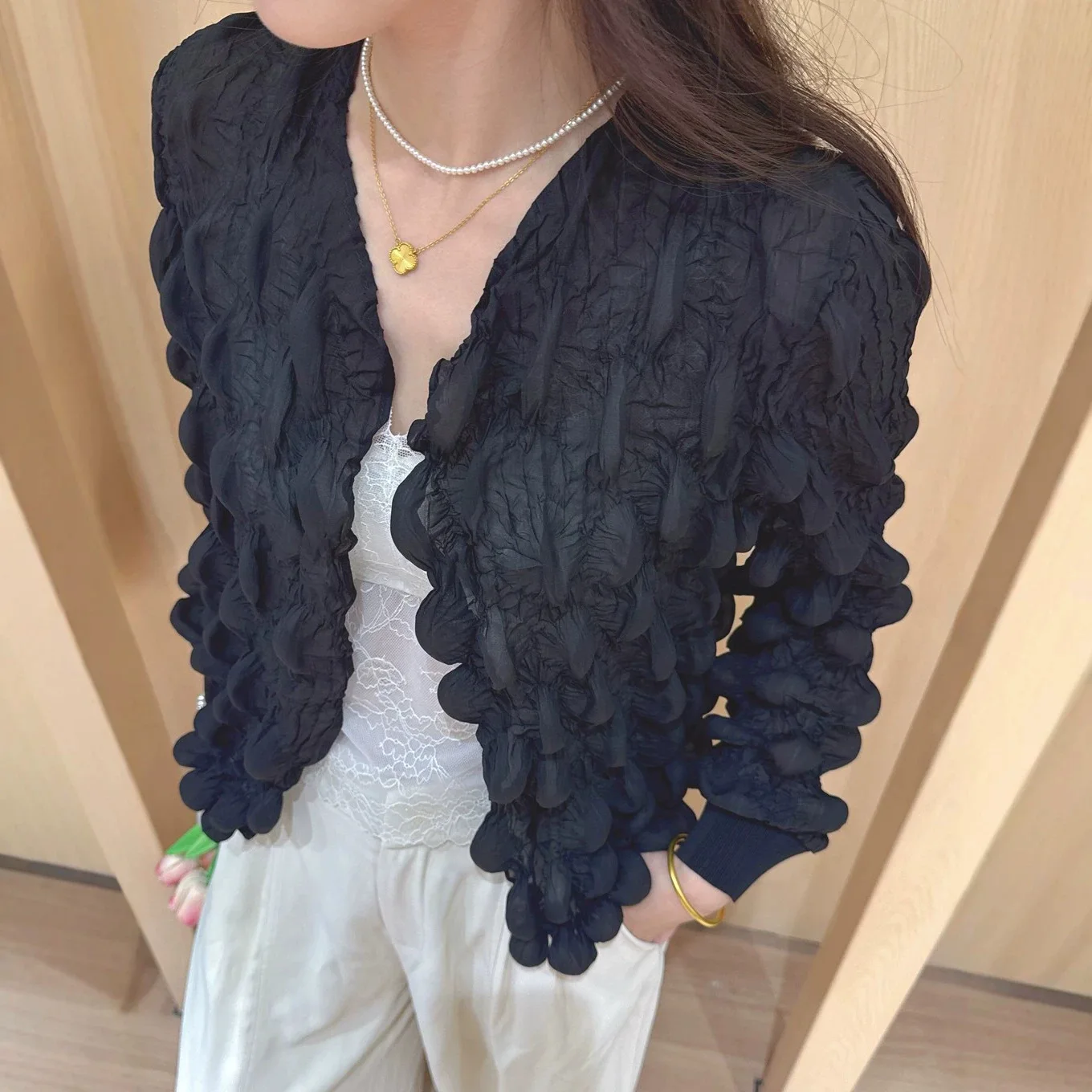 A stylish, loose-fitting, solid-color, versatile cardigan with a unique, design-conscious puff-pleated style.