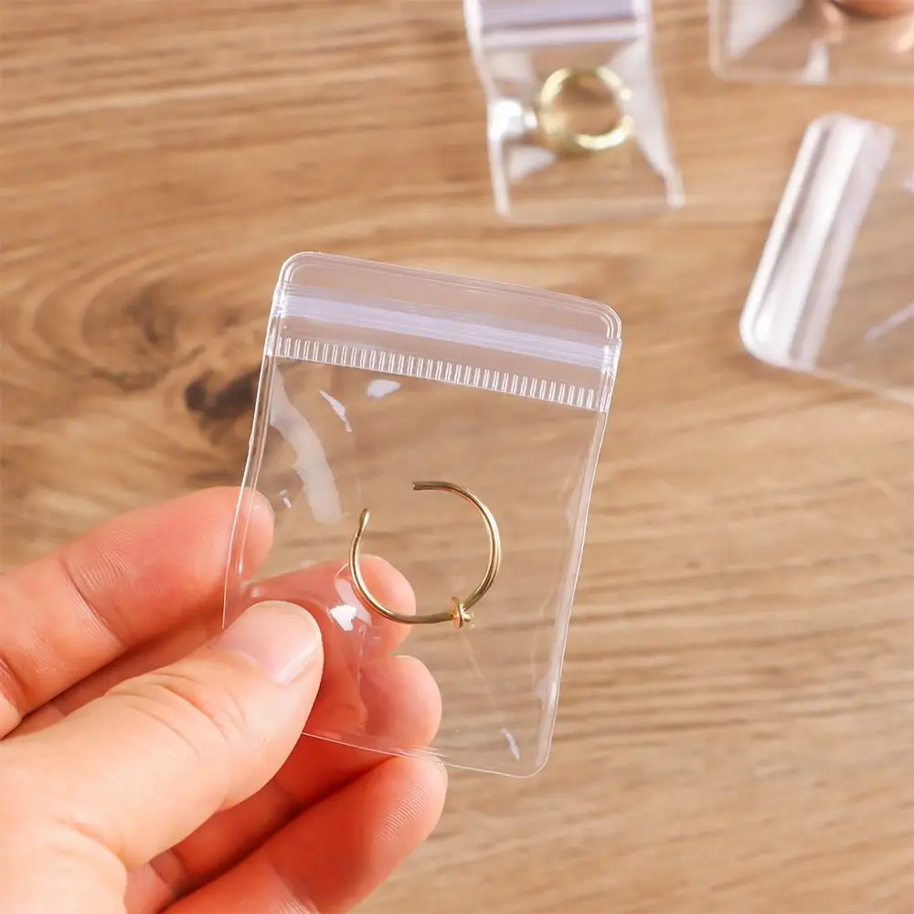 100 Stück neue selbstverschließende PVC-Kunststoffbeutel, staubdicht, wiederverschließbar, mit Reißverschluss, transparente Schmucktasche, Armband, Ring – Detail 9