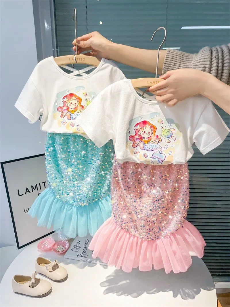 

Детский комплект из двух предметов: футболка с коротким рукавом и принтом русалки, белая, с пайетками, и юбка-русалка из сетки, блестящий, модный, милый.