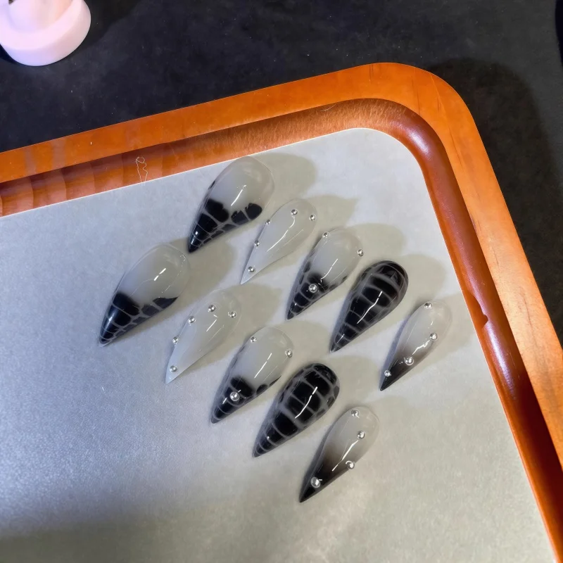 10PCS of white dagger-shaped fake nails with smoky black gradient snake-pattern print paired with mini silver metallic nails
