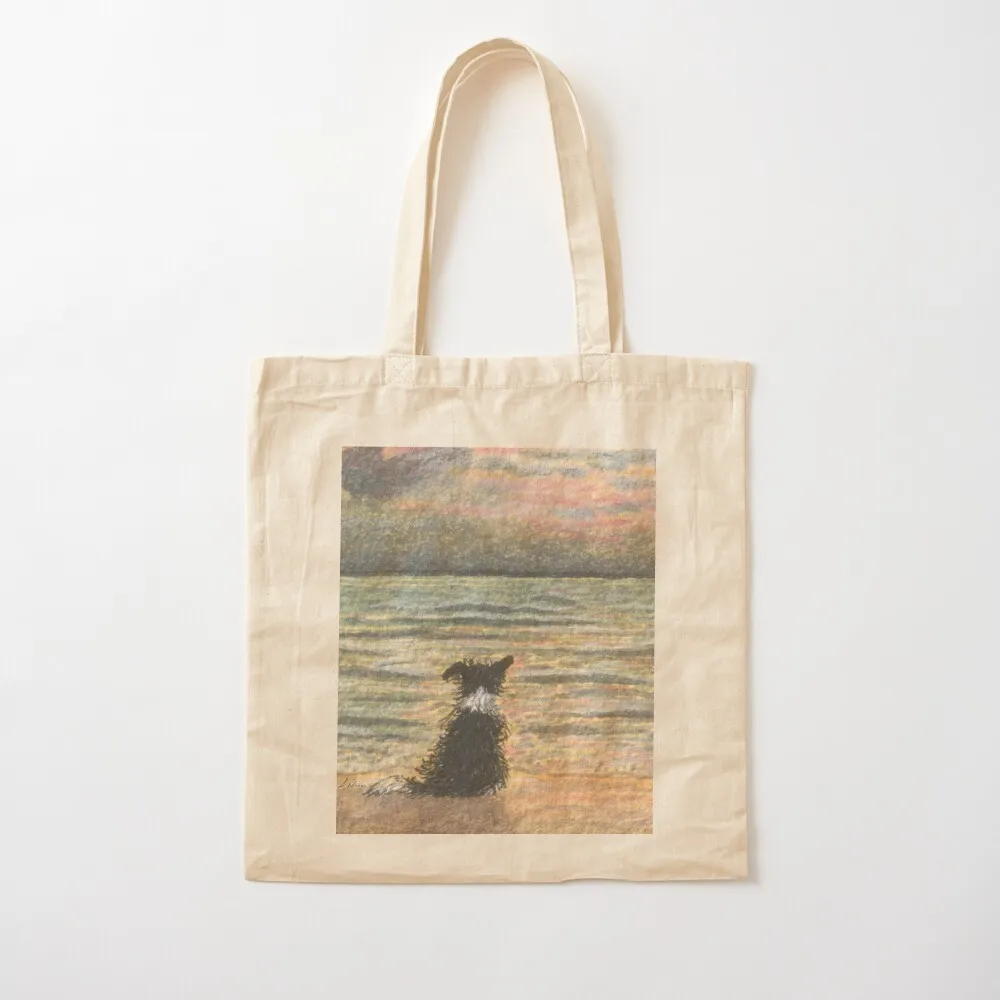 A Border collie dog gazes out over the ocean watching the sun come up, greeting the morning Tote Bag tote bag Canvas Tote Bag