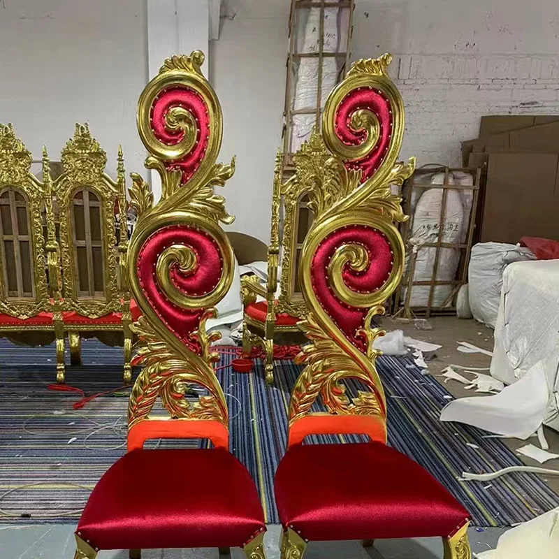 The lobby features high-backed gilded carved decorations paired with velvet upholstered chairs