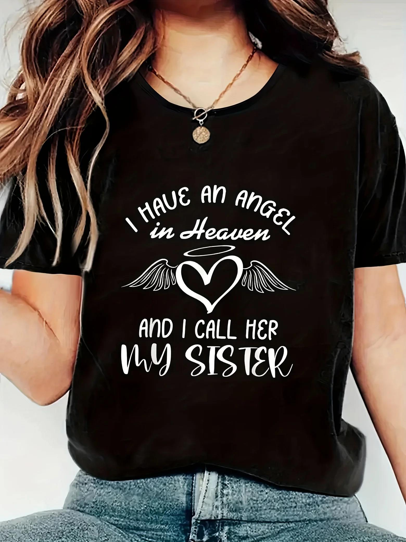 

Women's black pattern T-shirt - "I have an angel in heaven, I call her my sister", with a heart and wings design,
