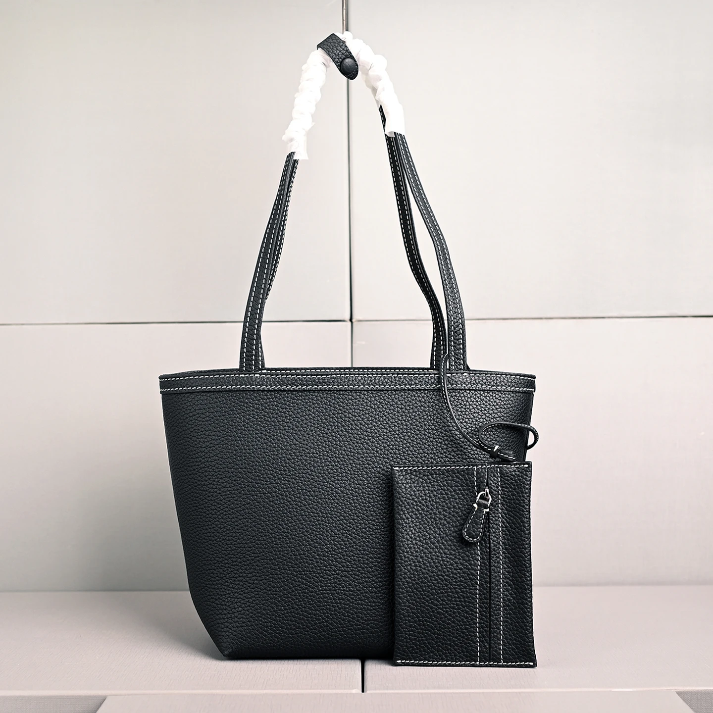 

Женская маленькая кожаная сумка-тоут из натуральной воловьей кожи, с длинными ручками, контрастной строчкой, в минималистичном стиле.