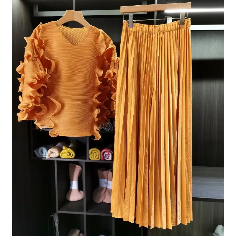 

Комплект из плиссированных брюк и топа Miyake 2026: топ с V-образным вырезом и деревянными элементами, свободная плиссированная юбка до колен, комплект из 2 предметов для женщин, коллекция Haute Sense