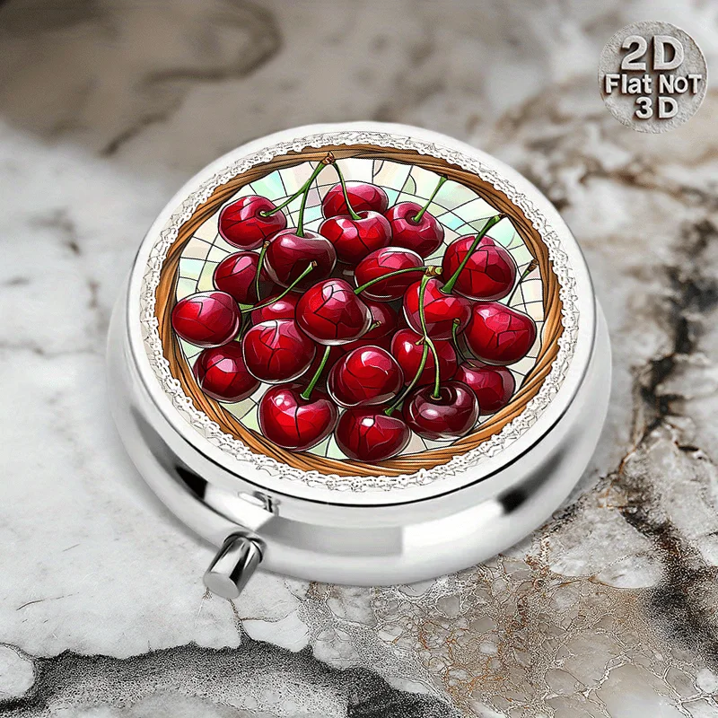 A flat, round metal pill storage box with a cherry design, featuring three compartments for storing medication and vitamins. It is a convenient storage solution for your medication