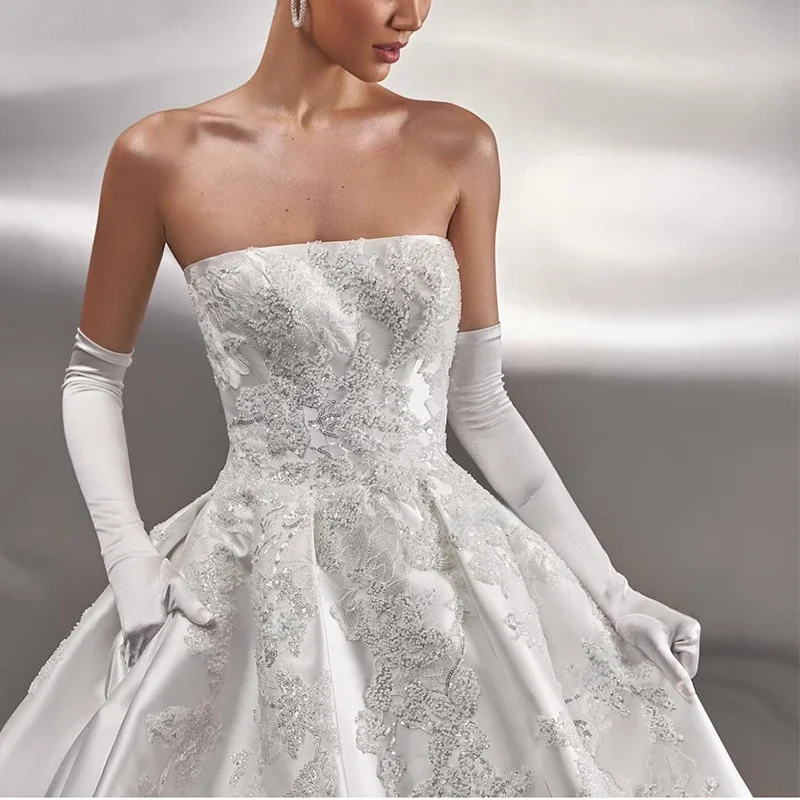 فستان زفاف من الساتان بدون حمالات مخصص لعام 2025 مطرز بالدانتيل على شكل حرف a فستان الأميرة بدون أكمام فستان الزفاف رداء