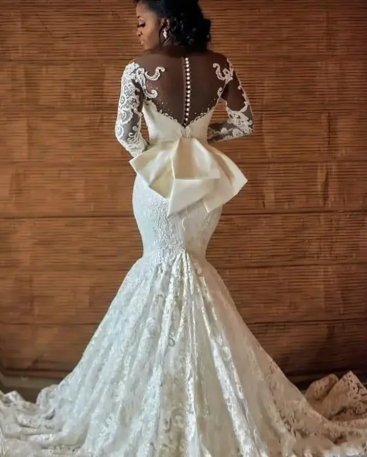 Abiti da sposa africani personalizzati in pizzo a sirena Vestido De Noiva Abiti da sposa da donna Manica lunga Fiocco con bottoni posteriori Sposa trasparente
