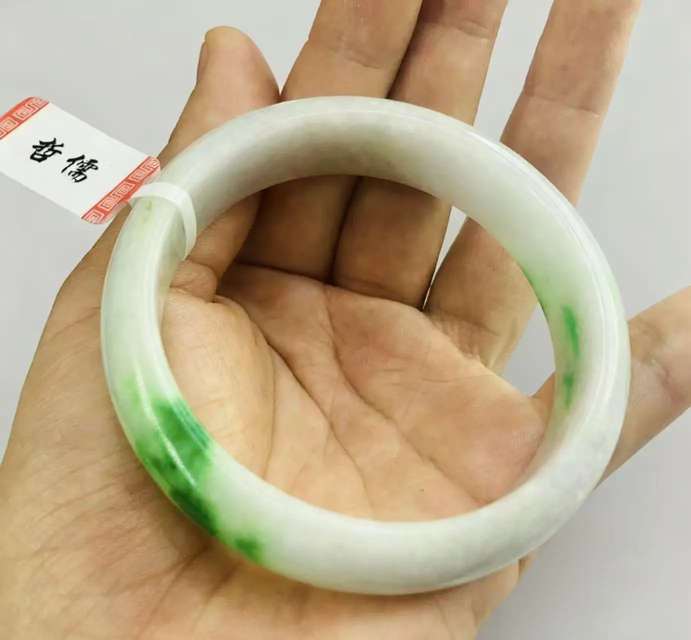 

Один на одной настоящей стрельбе большого нефритового браслета светло-зеленого цвета 60,9 мм.