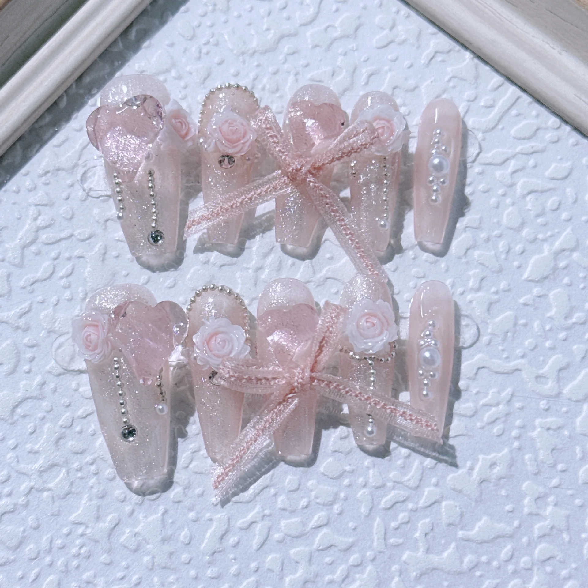 10ชิ้นเล็บปลอมสีชมพูอ่อนแบบยาวกดบนเล็บทำมือพร้อมโบว์ดอกไม้ไข่มุกออกแบบรูปหัวใจศิลปะตกแต่งเล็บเล็บเกาหลี