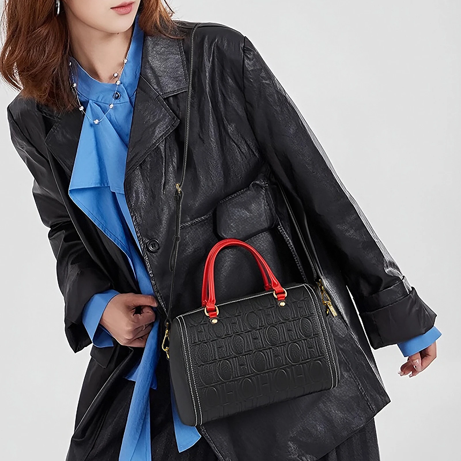 

Urban EleganceSleek Black Calfskin Tote with Crimson Crossbody Strap Gold Hardware
