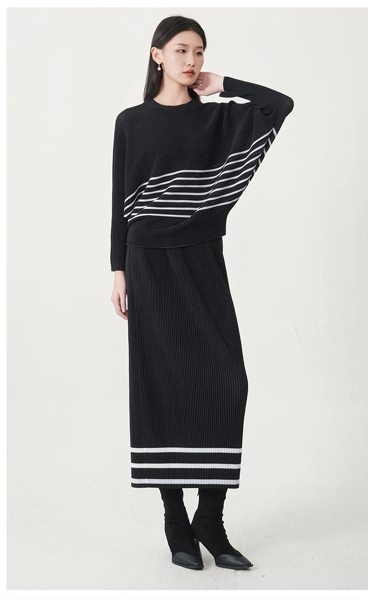 A trending women's clothing item for 2026: a matching black batwing-sleeved striped T-shirt and straight-cut skirt set by Miyake