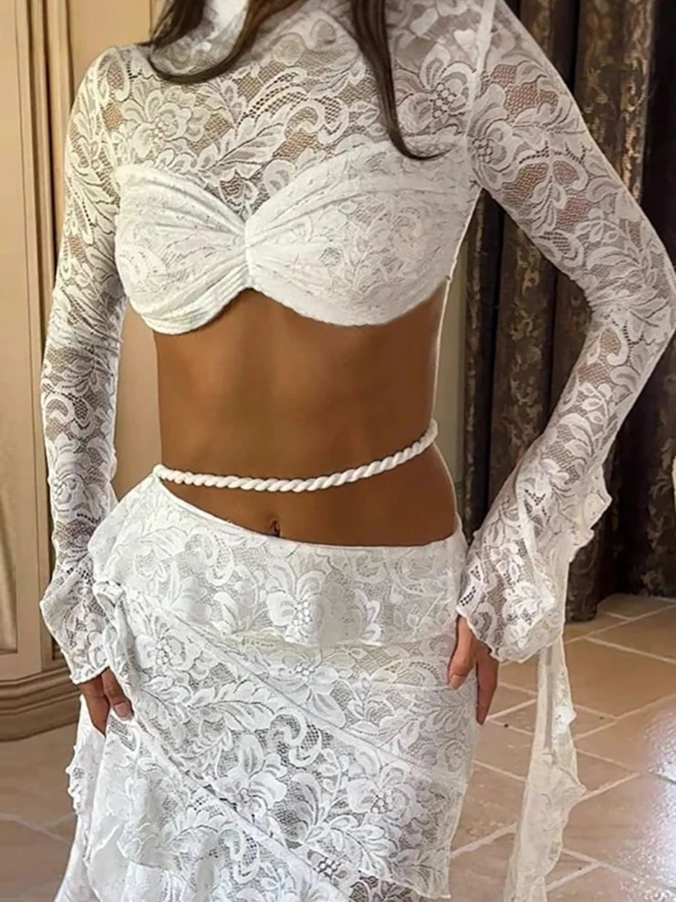 

Комплект: укороченный топ с вырезом на шее, открытым животом, длинными рукавами, кружевной лентой и многослойной юбкой с оборками, в стиле сексуального пляжного отдыха.