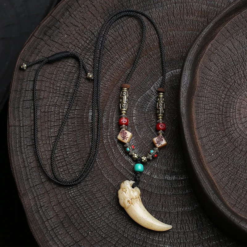 

Handcrafted Tibetan-style necklace with antique bone carving pendant, antique glass dice accessories, and sweater chain