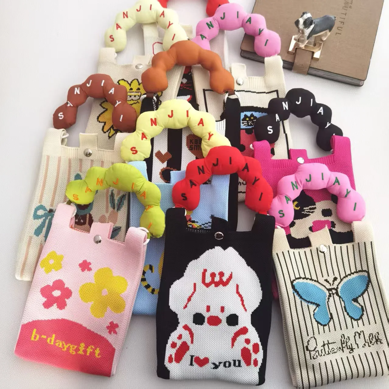 حقيبة معصم أنيقة بتصميم كرتوني محبوك، مصنوعة من البوليستر المتين مع إغلاق داخلي بمشبك، تصميم عمودي لحمل الهاتف المحمول للمراهقين