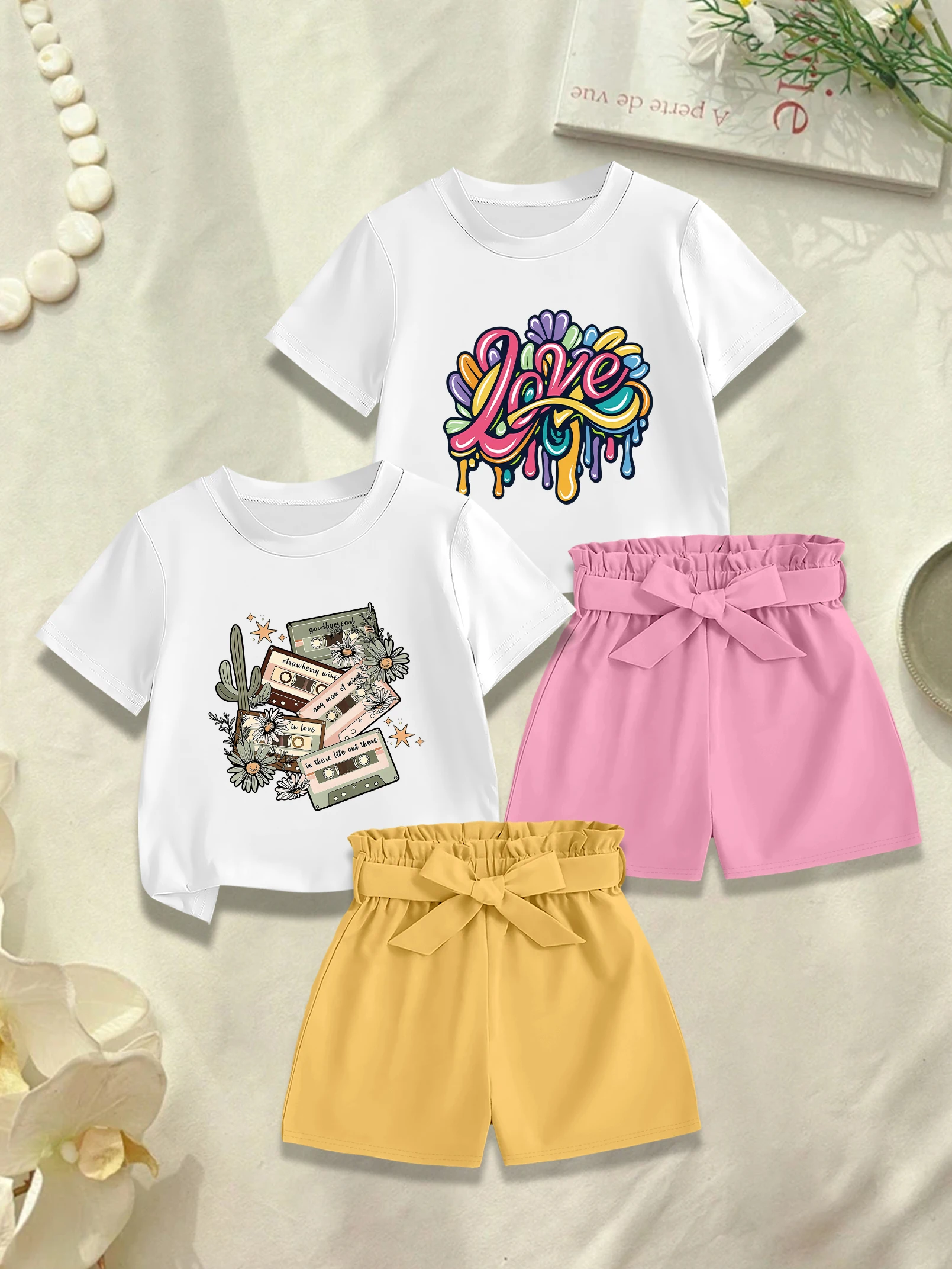 

4 предмета: летний комплект для девочек, футболка с мультяшным принтом и цветным английским надписью, тканевые шорты с бантом.