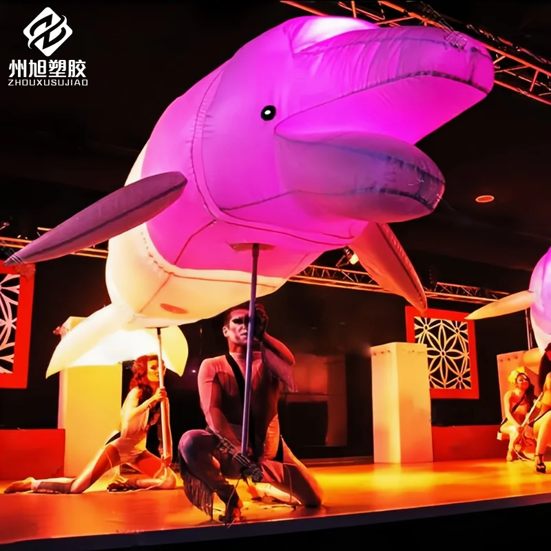 Inflatable interactive props for marine life parade performances with hands holding simulated dolphins and whales