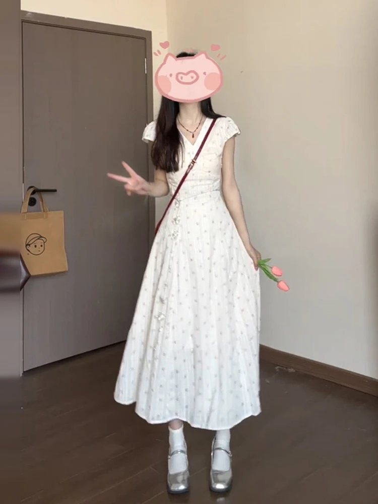 เดรสยาวทรงเอลายดอกไม้สีขาว คอวี สำหรับผู้หญิง ฤดูร้อน 2025 รุ่นใหม่ สไตล์ชายหาด เอวสูง ผ้าฝ้าย หวาน สไตล์เดรสชายหาด