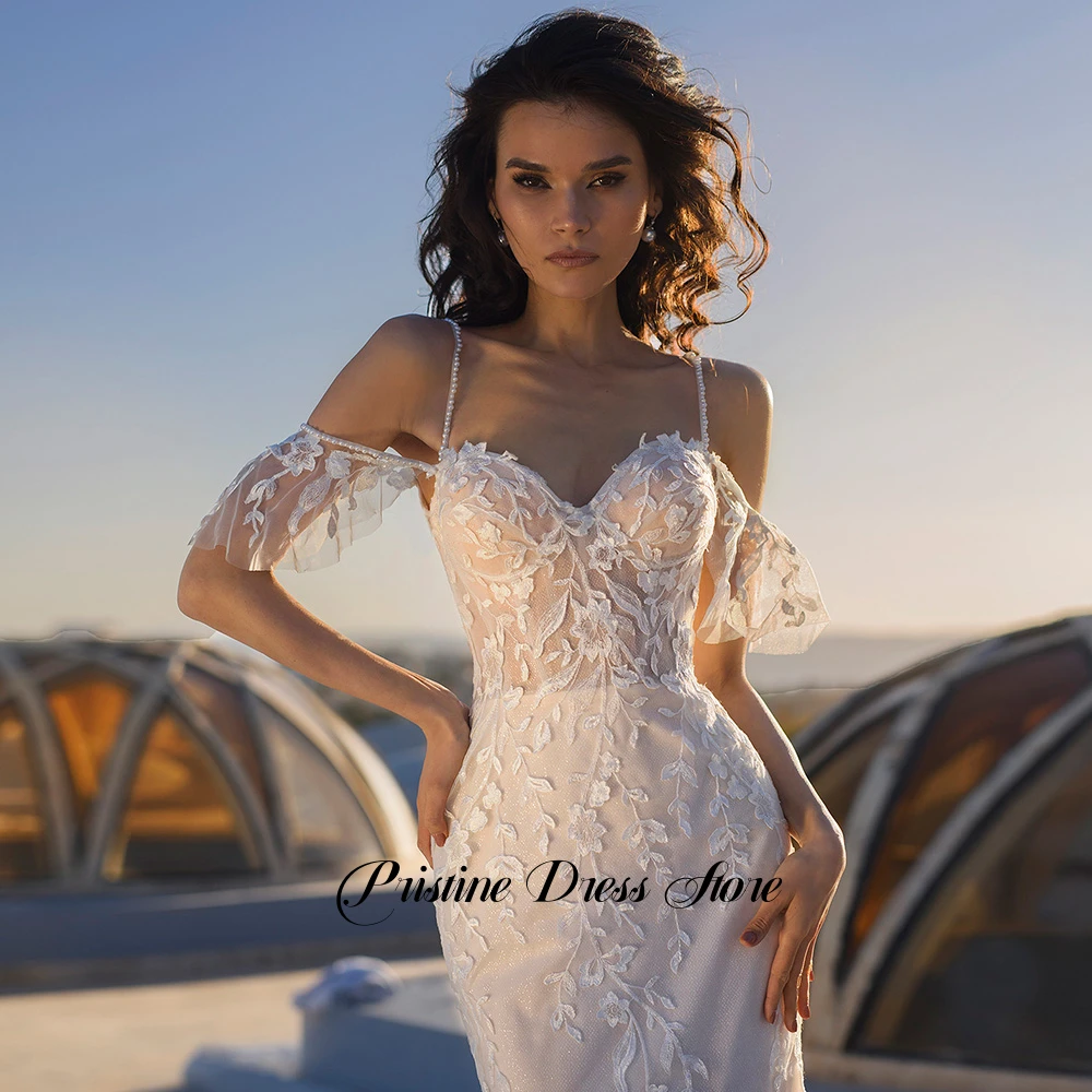 Urocza suknia ślubna w stylu syreny z trenem typu court, aplikacjami, ramiączkami spaghetti, długości do podłogi, tiulowa suknia ślubna szyta na miarę.