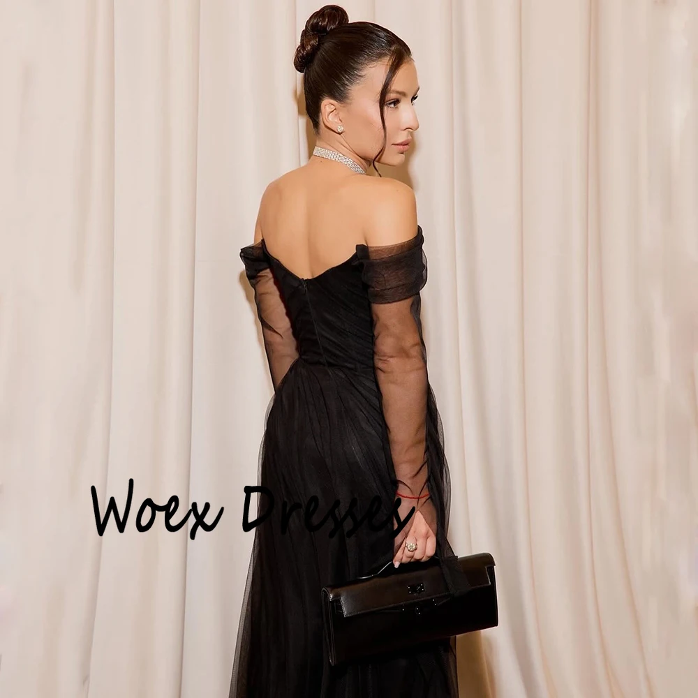 Sukienka wieczorowa z czarnego tiulu z dekoltem w łódkę, z iluzorycznymi, długimi rękawami, trenem zamiatającym, odkrytymi plecami, do ziemi, idealna na studniówkę.