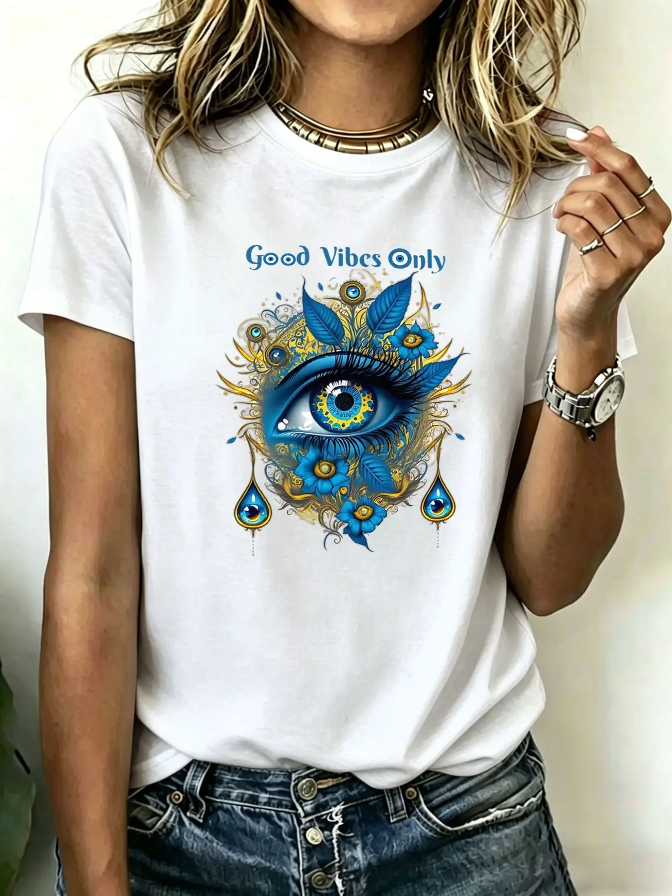 Camiseta feminina plus size com corte solto, estampa floral com olho azul marcante e a inscrição “Good Vibes Only”, gola redonda, mangas curtas, b