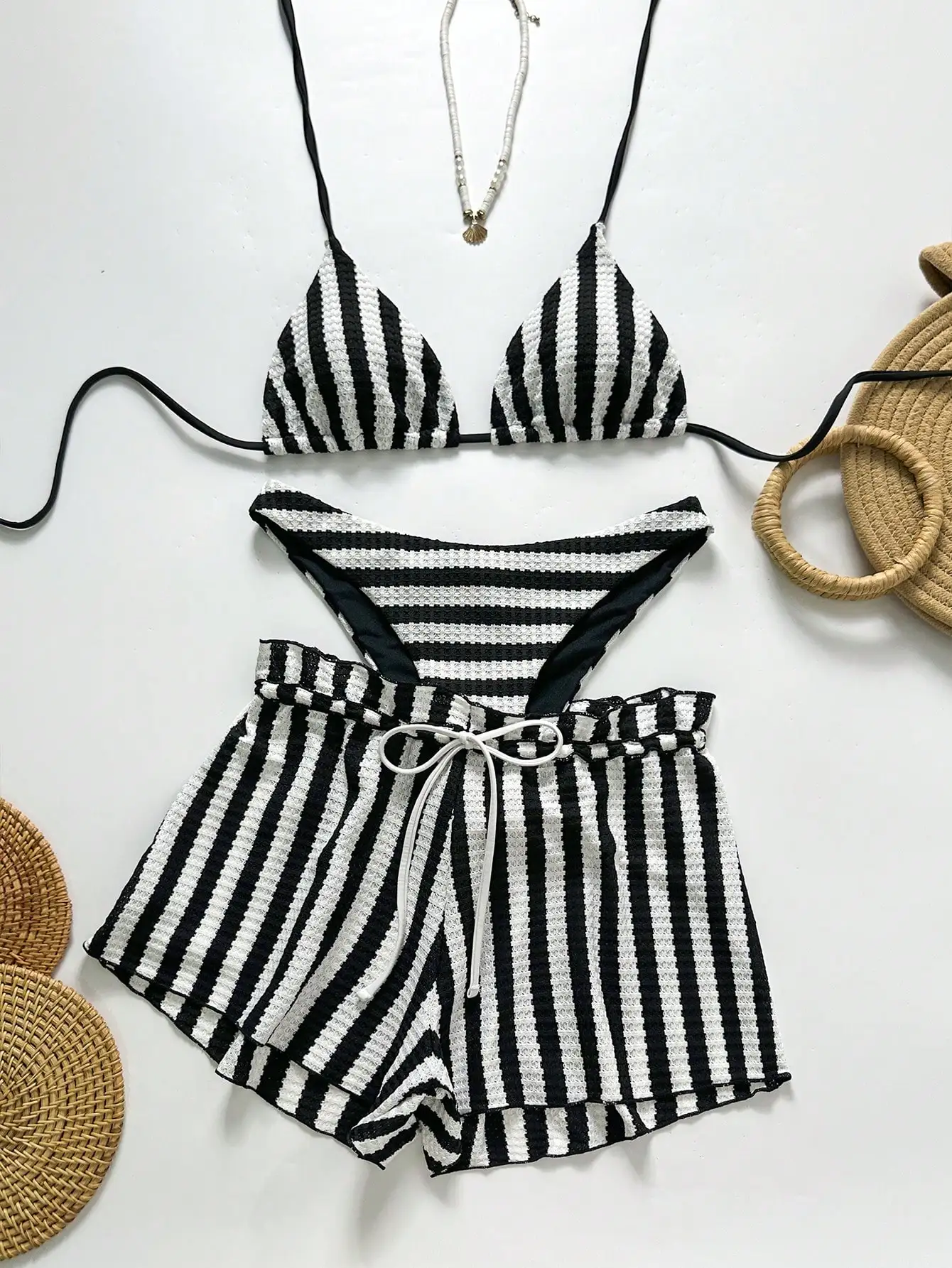 

Черно-белый полосатый треугольный купальник с шортами с высокой талией и накидкой на завязках для пляжного отдыха.