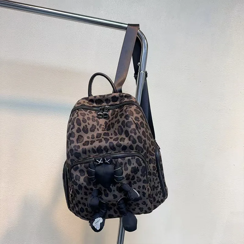 

2025 новый модный тренд, персонализированный женский рюкзак с леопардовым принтом, нейлоновая милая кукла, повседневная универсальная сумка на плечо для путешествий