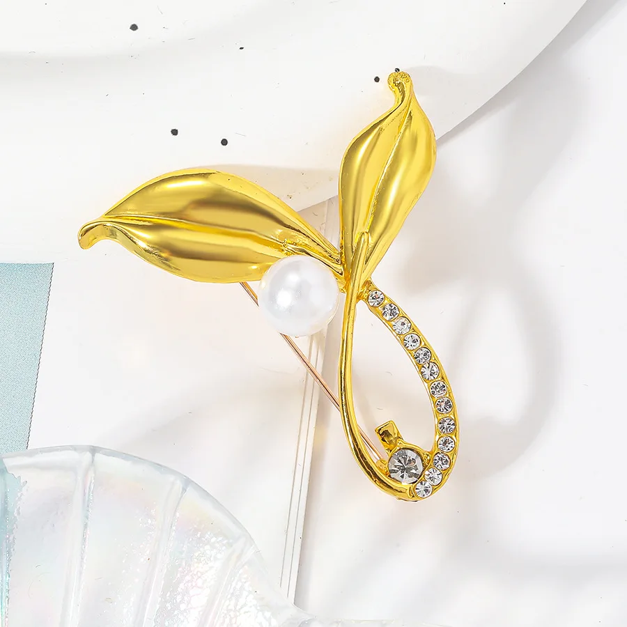 

Minimally smooth leaf design with versatile diamond studded pearl fish tail brooch, leaf breast flower