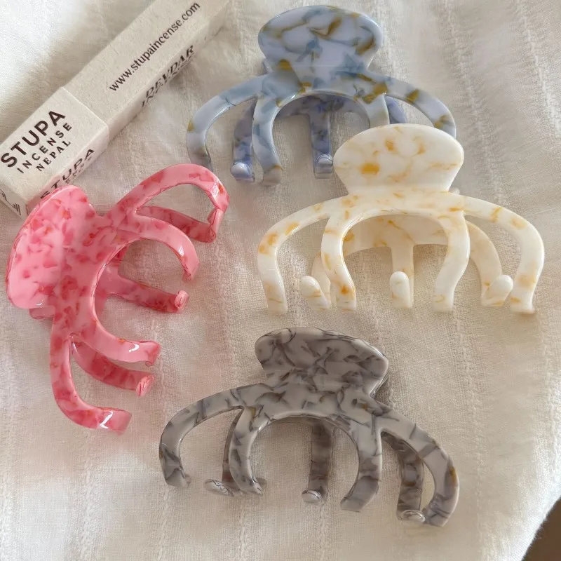 Ink smudged marble pattern five-tooth acetate gripper. large arc cut out design. stable hair grip. transparent and gentle
