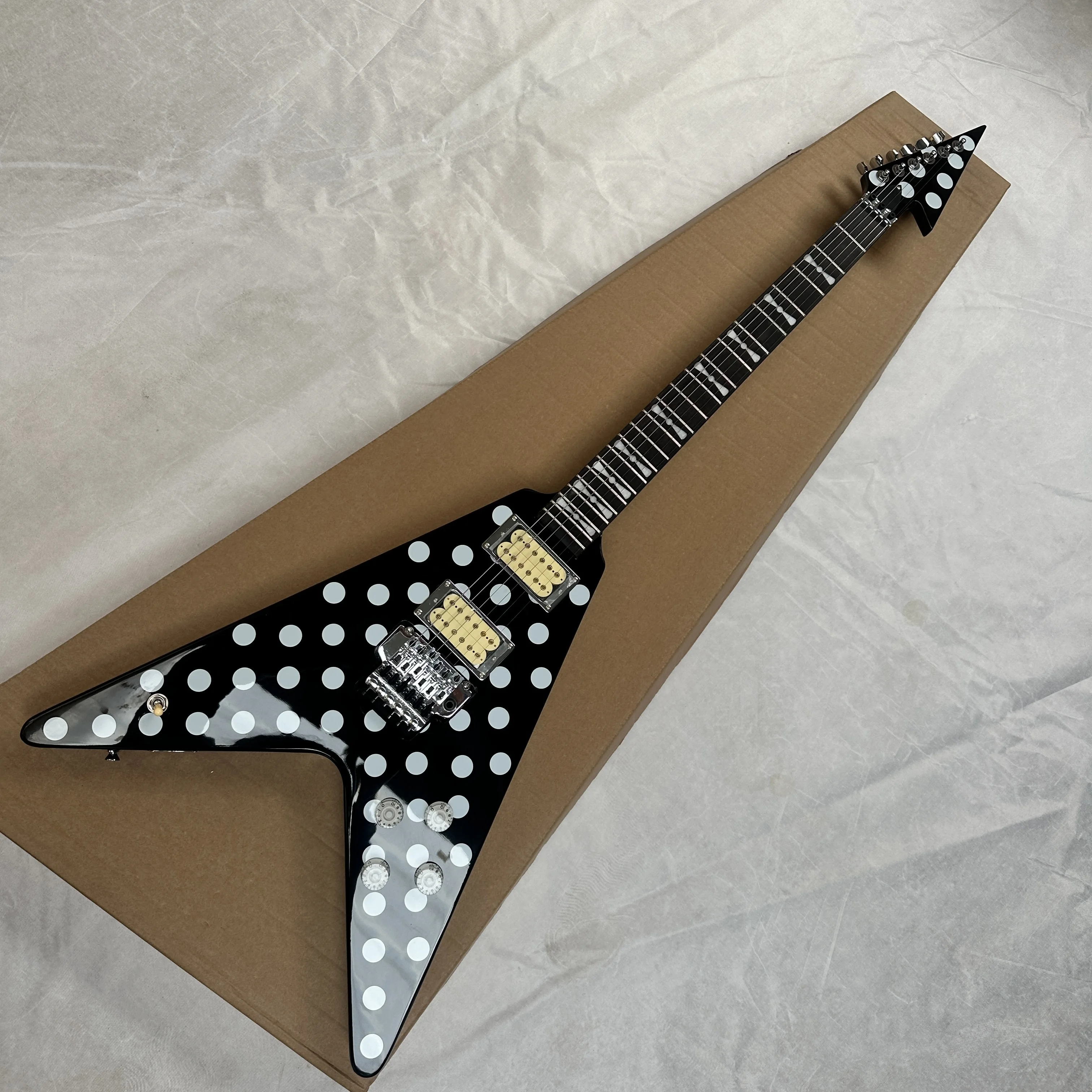 Guitarra eléctrica con fondo negro y puntos blancos en forma de V, sistema de vibrato con pastillas HH, guitarra eléctrica marca Butterfly Knot