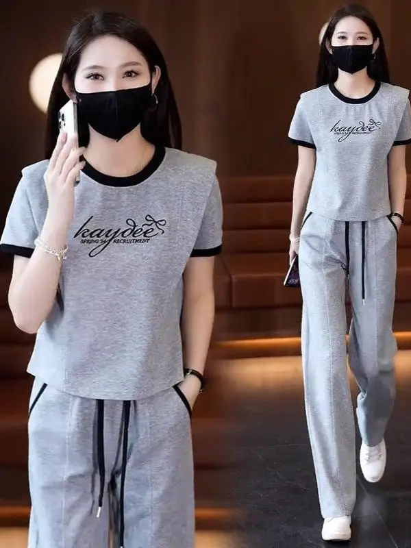 

Модный хлопковый спортивный костюм для женщин, лето 2026: трендовый комплект из двух предметов с широкими брюками и укороченным топом с круглым вырезом