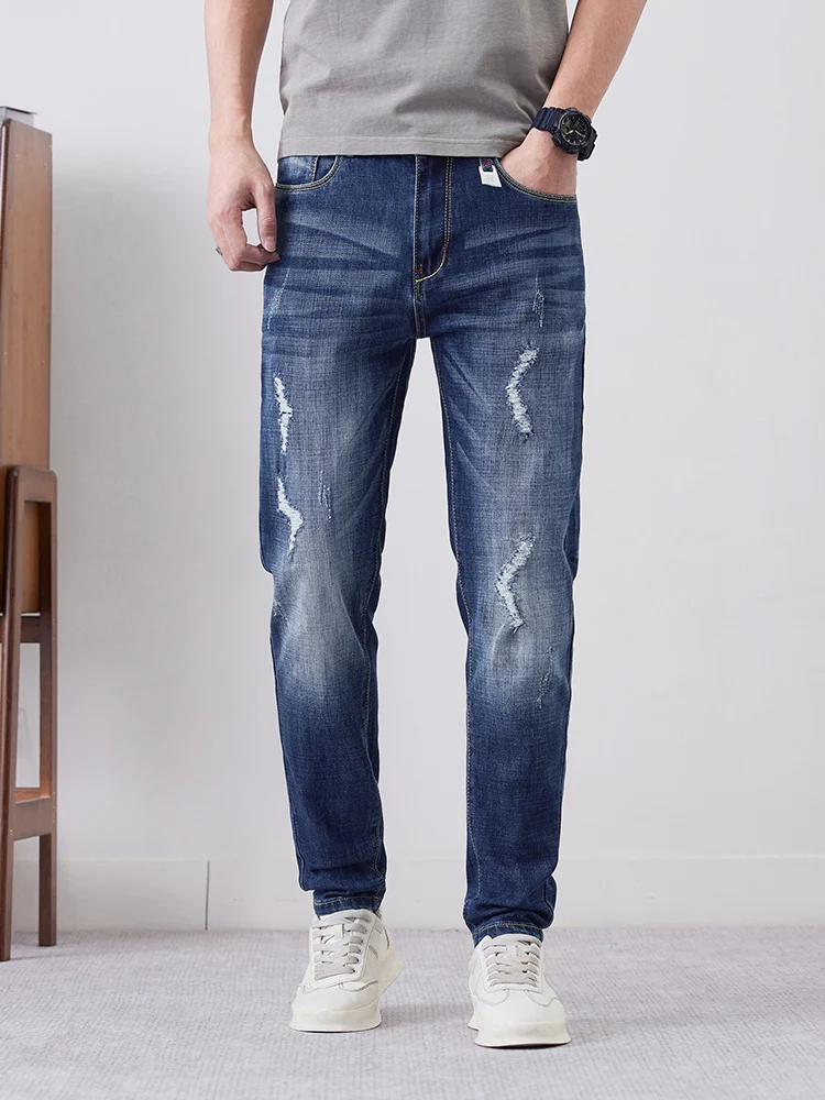 

Рваные эластичные джинсы. Мужская мода. Персонализированная уличная одежда. Брюки в стиле хип-хоп. Тонкие джинсовые брюки с эффектом потертости.