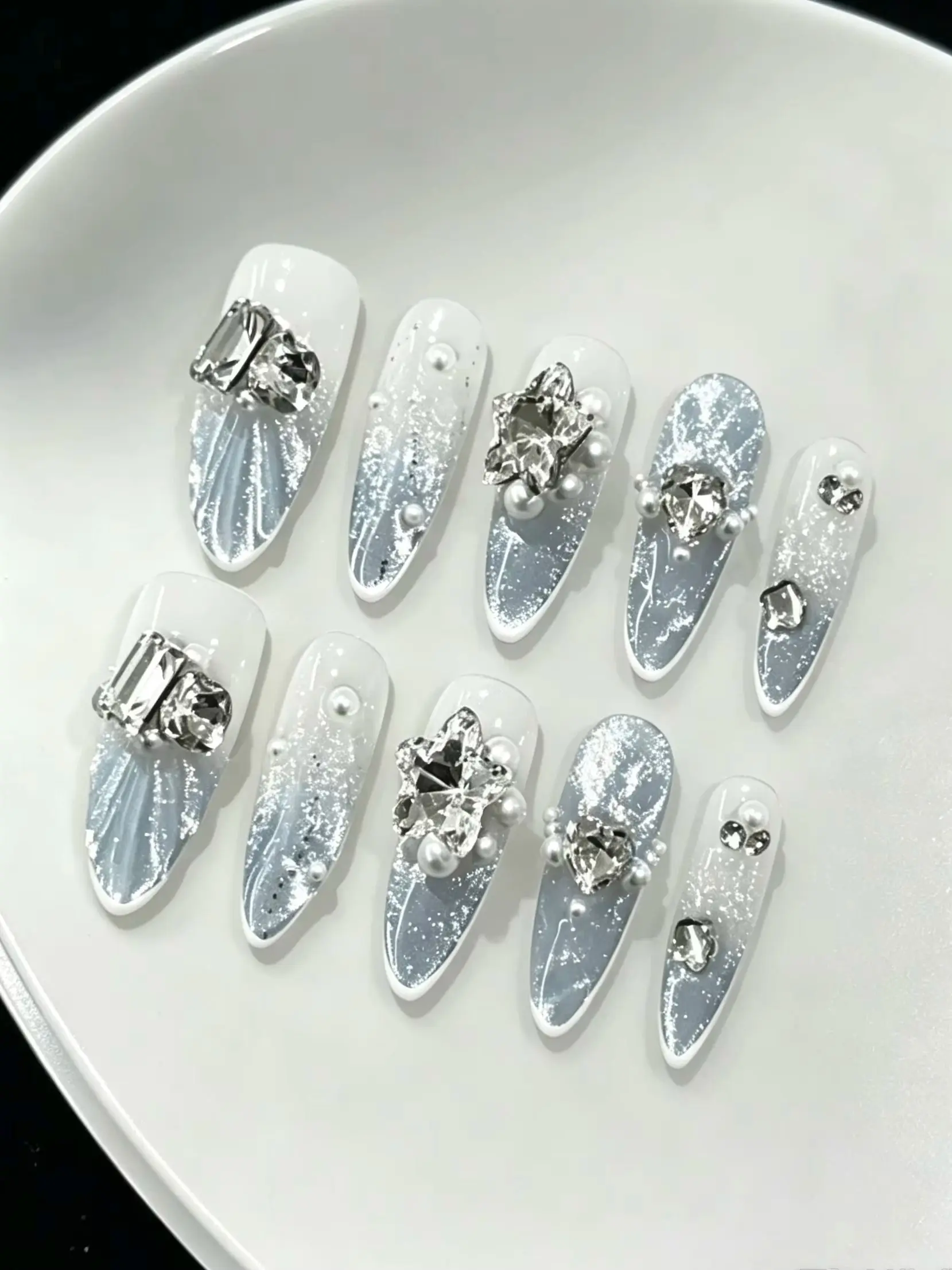 10-Piece Set of Ice Blue Crushed Diamond Sea Salt Pearl Almond Press-On Nails, with a Milky White Transition to Smoggy Ice Blue, Silver Foil Glitter, Flowing Texture, and a Refreshing Water-Like Shine, Includes Jelly Glue and a Nail File