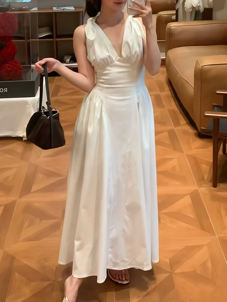 Deep V-necked halter dress with wide sleeves, fitted at the waist, revealing the back, women's style, summer 2026 new collection