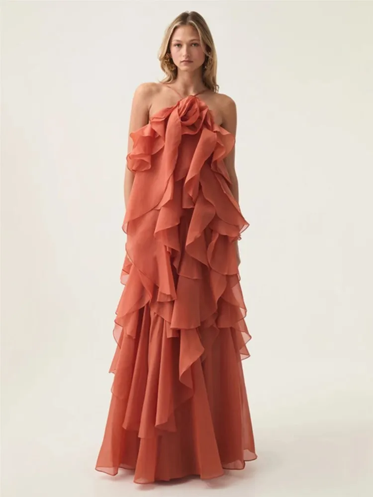 An elegant long dress with a three-dimensional flower decoration around the neck large backless display and ruffles
