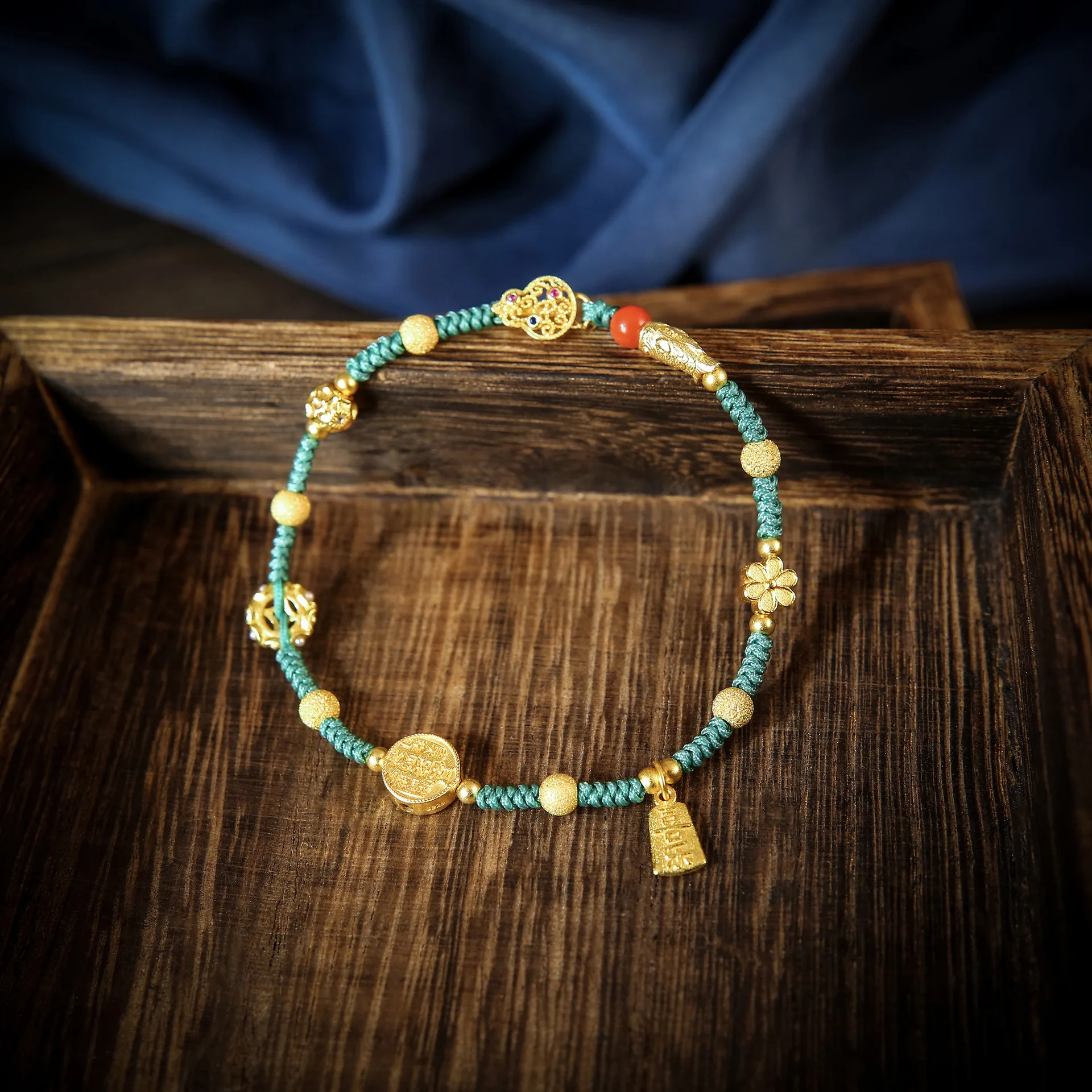 

Бирюзовый плетеный шнурок с золотым кулоном – украшение в благоприятном восточном стиле