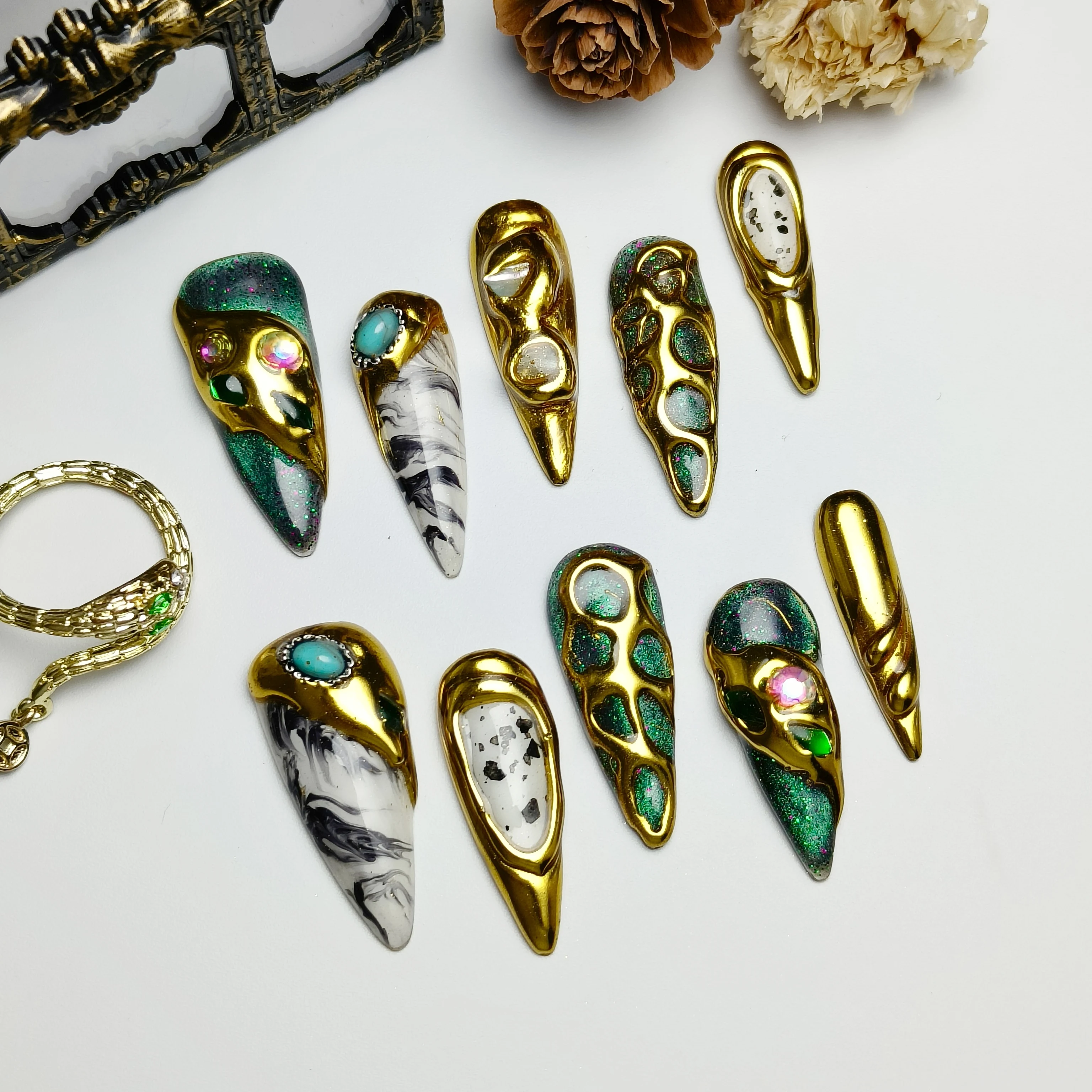 

Handcrafted, slender-stiletto-style nails in green-gold glitter; reusable nail wraps suitable for both parties and everyday use.