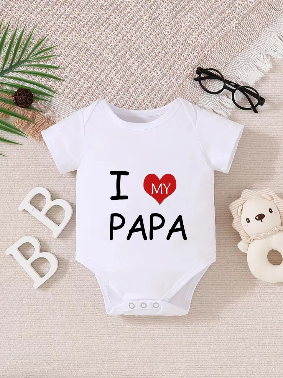 Playful letter-printed baby short-sleeve triangle bodysuit. Button closure for easy dressing, machine washable