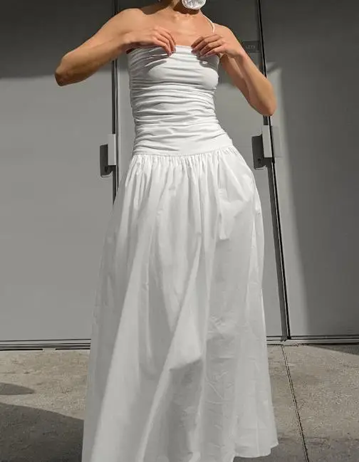 Biała sukienka bez ramiączek z odkrytymi ramionami, dopasowana, z niskim stanem, letnia sukienka bez rękawów z kwiatowym zdobieniem.