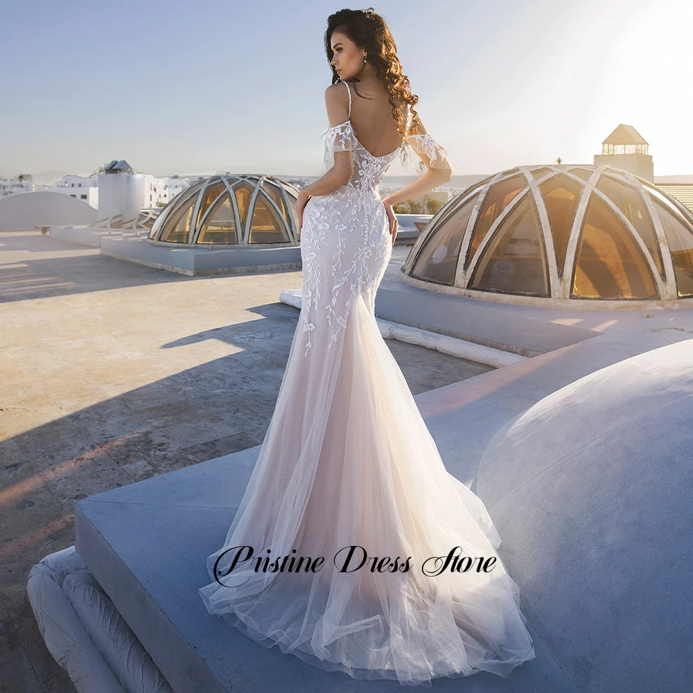 Urocza suknia ślubna w stylu syreny z trenem typu court, aplikacjami, ramiączkami spaghetti, długości do podłogi, tiulowa suknia ślubna szyta na miarę.